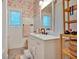 Bathroom with a floral wallpaper, single sink vanity, and accent wooden shelving at 1421 Hendon Rd, Woodstock, GA 30188