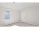 Bright, carpeted bedroom with a large window offering a view of the outdoors at 238 Linford Dr, Locust Grove, GA 30248