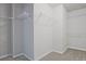 Spacious walk-in closet featuring ample shelving for storage and organization with neutral walls and carpet at 238 Linford Dr, Locust Grove, GA 30248