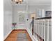 Light-filled hallway showcasing hardwood floors, white wainscoting, and a view to the front door at 4676 Ivygate Se Cir, Atlanta, GA 30339