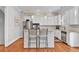 Kitchen with bar seating, stainless appliances, light gray walls and hardwood floors at 4676 Ivygate Se Cir, Atlanta, GA 30339