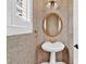 Unique powder room featuring wallpaper, white pedestal sink, gold fixtures, and window with blinds at 4676 Ivygate Se Cir, Atlanta, GA 30339
