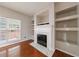 Cozy living room with fireplace, built-in shelves, hardwood floors, and a large window at 4844 W Park Cir # 4844, College Park, GA 30349