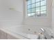 Close-up of a soaking tub with chrome fixtures and a bright window at 55 Fox Chase, Covington, GA 30016