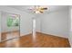 Bright bedroom featuring hardwood floors, ceiling fan, and mirrored closet doors at 55 Fox Chase, Covington, GA 30016