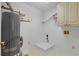 Well-lit laundry room equipped with washer and dryer hookups, water heater, and shelving at 55 Fox Chase, Covington, GA 30016