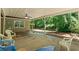 Spacious covered patio with outdoor seating and a view of the serene, wooded backyard at 55 Fox Chase, Covington, GA 30016