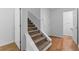 Carpeted stairs with white railing leading to the upper level, next to hardwood floor at 55 Fox Chase, Covington, GA 30016