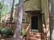 Charming home featuring a covered front entrance and wooden deck, surrounded by lush greenery and mature trees at 5826 Par Four Ct, Lithonia, GA 30038