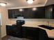 Kitchen featuring black appliances, updated black sink and faucet with matching dark cabinets at 5826 Par Four Ct, Lithonia, GA 30038