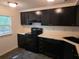 Kitchen featuring black appliances, updated black sink and faucet with matching dark cabinets at 5826 Par Four Ct, Lithonia, GA 30038