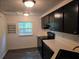 Kitchen featuring black appliances, updated black sink and faucet with matching dark cabinets and tile floors at 5826 Par Four Ct, Lithonia, GA 30038