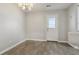 A modern dining room with an exit door and stylish floors and a chandelier at 107 Woodberry Ct, Woodstock, GA 30188