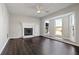 Bright living room with a fireplace, large windows, and dark wood flooring at 107 Woodberry Ct, Woodstock, GA 30188