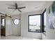 Modern bedroom featuring a ceiling fan, a round window, and black trimmed windows offering ample natural light at 1954 8Th St, Chamblee, GA 30341