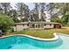 Scenic backyard featuring a swimming pool, lush lawn, and mature trees at 2568 Laurelwood Rd, Atlanta, GA 30360