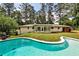 Expansive backyard featuring a refreshing in-ground pool, lush lawn, and the home's rear exterior at 2568 Laurelwood Rd, Atlanta, GA 30360