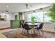 Charming dining area with a round table, modern lighting, and a unique green brick accent wall at 2568 Laurelwood Rd, Atlanta, GA 30360