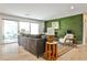Cozy living room with hardwood floors, green accent brick wall, sliding glass doors, and natural lighting at 2568 Laurelwood Rd, Atlanta, GA 30360