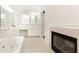 Bathroom featuring fireplace, jacuzzi tub, double vanity, and tiled floors at 2610 Oglethorpe Ne Cir, Brookhaven, GA 30319