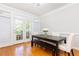 Dining room with a wooden table and bench seating, brightened by natural light streaming through the French doors at 2610 Oglethorpe Ne Cir, Brookhaven, GA 30319