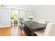 Sunlit dining area showcasing a dark wood table, bench, and chairs, with access to a balcony at 2610 Oglethorpe Ne Cir, Brookhaven, GA 30319