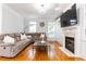 Elegant living room with hardwood floors, a cozy fireplace, built-in cabinets, and large windows at 2610 Oglethorpe Ne Cir, Brookhaven, GA 30319