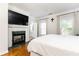 Well-lit main bedroom featuring fireplace, hardwood floors, large windows, and neutral paint at 2610 Oglethorpe Ne Cir, Brookhaven, GA 30319