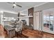 Elegant dining room with brick fireplace, glass table, white curtains, and access to the outdoor deck at 2716 Georgia 16, Carrollton, GA 30116