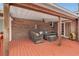 Inviting covered patio with brick wall, ceiling fan, wood beams, stylish seating, and sliding glass doors to the interior at 2716 Georgia 16, Carrollton, GA 30116