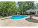 Large in-ground pool surrounded by lush landscaping, offering a private and serene outdoor space at 2936 Summitop Ne Rd, Marietta, GA 30066