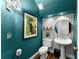Stylish powder room featuring teal walls, decorative wallpaper, pedestal sink, and hardwood flooring at 2936 Summitop Ne Rd, Marietta, GA 30066