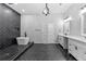 Contemporary bathroom boasts a soaking tub, dual sink vanity, tile accent wall and herringbone tile flooring at 378 Grant Park Pl, Atlanta, GA 30315