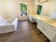 Bright bathroom with a soaking tub, double sink vanity, wood flooring and large window at 6370 Maid Marion Close, Alpharetta, GA 30005
