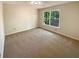 Bedroom with neutral colored walls and carpet and a large window at 6370 Maid Marion Close, Alpharetta, GA 30005
