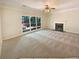Sunlit living room with a fireplace, carpeted floors, large windows, and ample space for entertaining at 6370 Maid Marion Close, Alpharetta, GA 30005