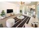 Bright, staged living room featuring a plush sofa, modern furnishings, and an open layout to the kitchen at 6370 Maid Marion Close, Alpharetta, GA 30005