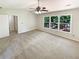 Large main bedroom featuring a fan, large windows, and neutral colored walls and carpet at 6370 Maid Marion Close, Alpharetta, GA 30005