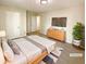 Staged main bedroom featuring a comfortable bed, sleek dresser, and ample natural light at 6370 Maid Marion Close, Alpharetta, GA 30005