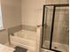 Bathroom showcasing a soaking tub and a shower with black trim and neutral tiles at 6780 Cedar Glen Rd, Peachtree Corners, GA 30360