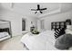Spacious bedroom with a tray ceiling, white walls, and modern decor. Doorway leading to bathroom at 6780 Cedar Glen Rd, Peachtree Corners, GA 30360
