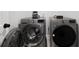Modern laundry room featuring front load washer and dryer in a neutral color scheme at 6780 Cedar Glen Rd, Peachtree Corners, GA 30360