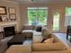 Cozy living room with fireplace, large sectional sofa, and backyard view at 6780 Cedar Glen Rd, Peachtree Corners, GA 30360
