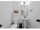 Small and efficient powder room featuring a toilet, pedestal sink, and modern fixtures, providing convenience for guests at 6780 Cedar Glen Rd, Peachtree Corners, GA 30360
