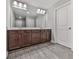 Bathroom featuring wood cabinets, a double sink, large mirror, and gray wood flooring at 1020 Broadview Dr, Marietta, GA 30062