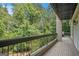 View from balcony overlooking lush greenery, metal railing, and wood flooring at 3192 Paces Mill Rd, Atlanta, GA 30339