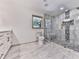 Updated bathroom features a custom glass shower, a stone floor, and marble counters with modern fixtures at 221 Wonewok Dr, Canton, GA 30114