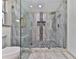 Beautiful glass shower features unique tiling, gold fixtures, a built-in seat, and a rainfall shower head at 221 Wonewok Dr, Canton, GA 30114