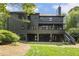 Rear exterior view of the home featuring a large deck, manicured lawn, and wooded backdrop at 320 Shady Grove Ln, Alpharetta, GA 30009