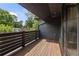 Spacious wooden balcony with dark railings and view of lush trees at 320 Shady Grove Ln, Alpharetta, GA 30009